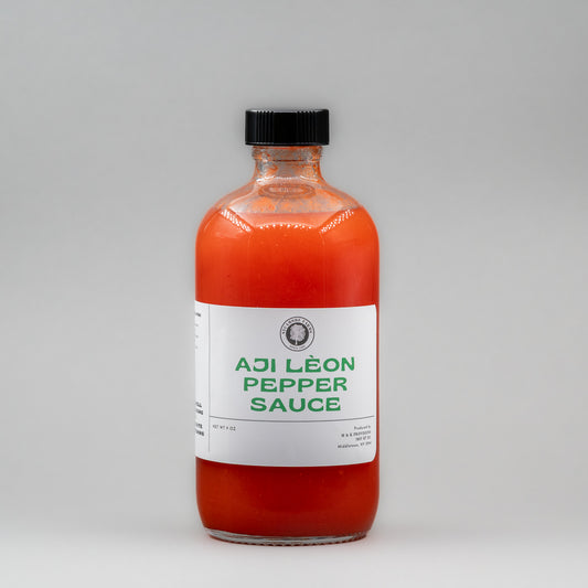 Sealed glass jar of small-batch local NY Aji Leon Pepper Sauce by Sycamore Farms, produced by M&K Provisions.